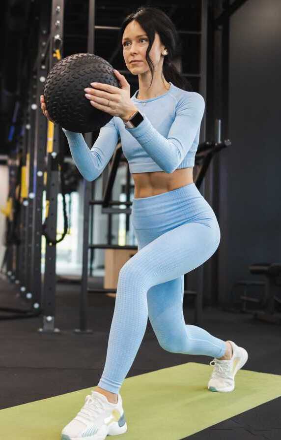 woman doing lunge with a medicine ball